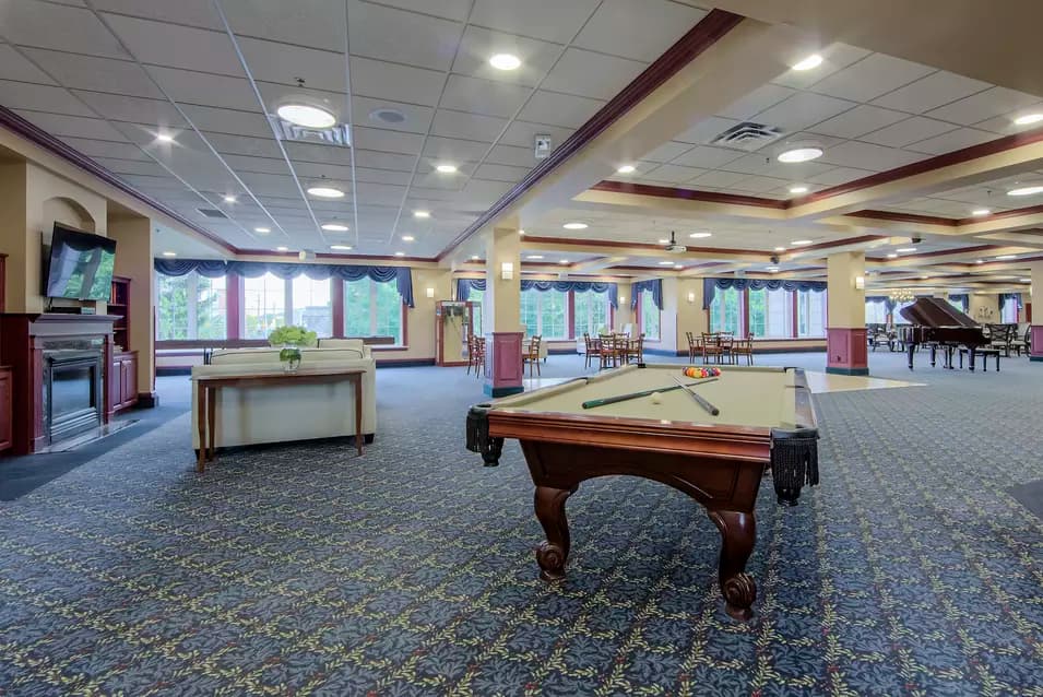 Chartwell Terrace on the Square's common area for entertainment with pool table, piano, tv over fireplace