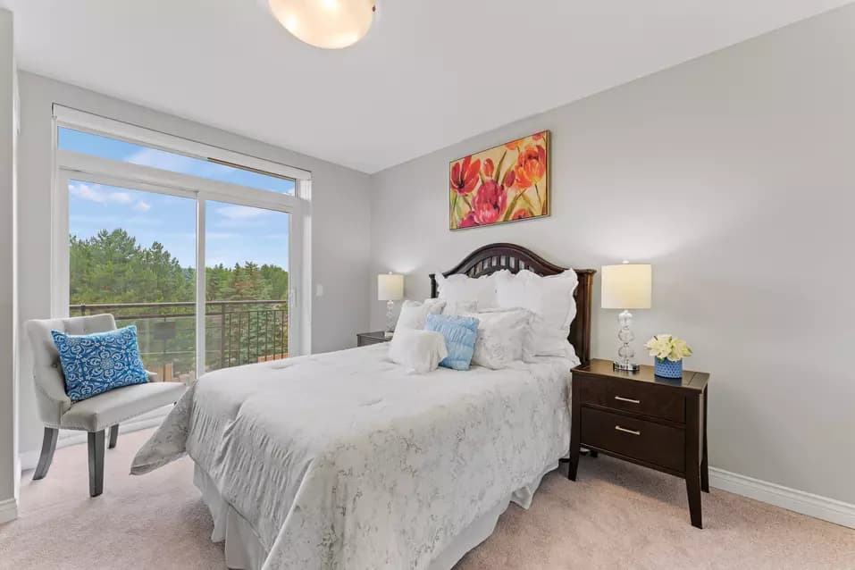 Bedroom with a window to a in suite balcony at Chartwell Clair Hills / Chambre avec fenêtre donnant sur le balcon de la suite chez Chartwell Clair Hills