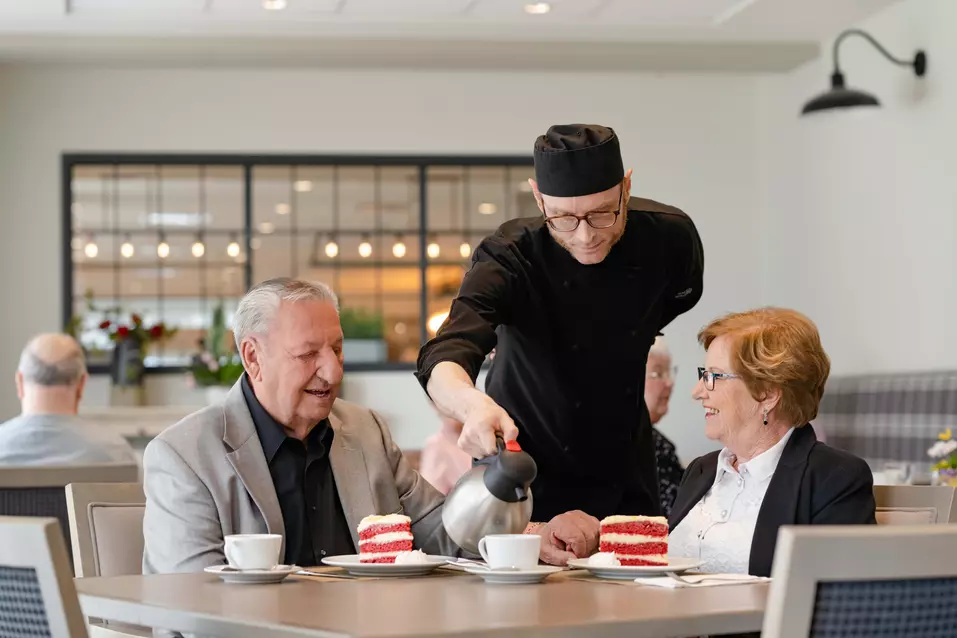 Chartwell staff server serving coffee/tea and dessert to the Chartwell senior residents in Dinning room