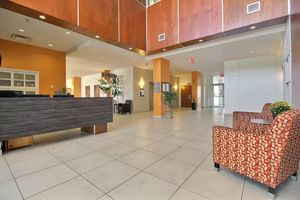 Réception de la résidence avec aire d'attente Chartwell Jardins Notre-Dame résidence pour retraités retirement residence Front desk with waiting area and chairs