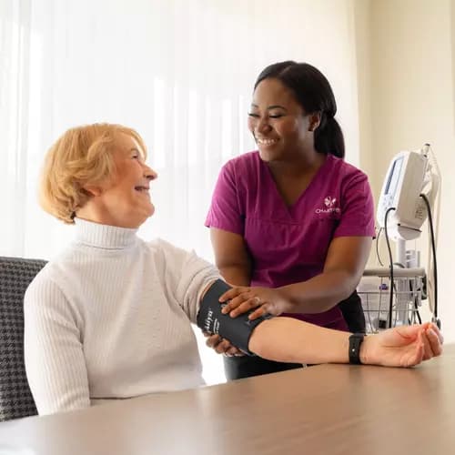 Care nurse measuring blood pressure of the Chartwell senior resident